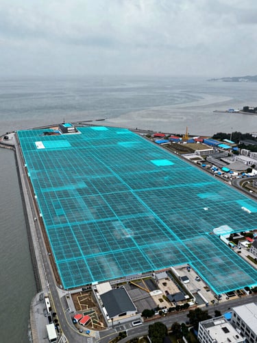 Top-down orthomosaic mapping overlay on a coastal development site, sharp cyan vector grid lines, cool overcast daylight, high-contrast technical photography, 35mm lens
