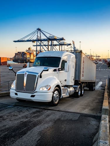 A low-angle heroic shot of a clean modern semi-truck at a Jacksonville terminal, bright morning sun, high-contrast industrial editorial style