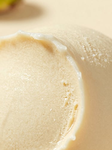 Macro close-up of freshly folded pistachio gelato with rich creamy texture, soft natural daylight, shallow depth of field, warm ivory background