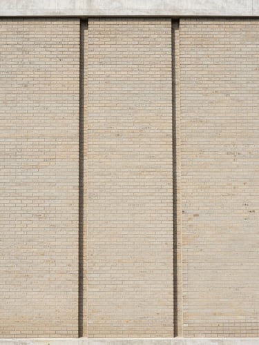 Straight-on architectural photograph of a renovated brick building facade, clean vertical lines, soft natural daylight, 35mm lens