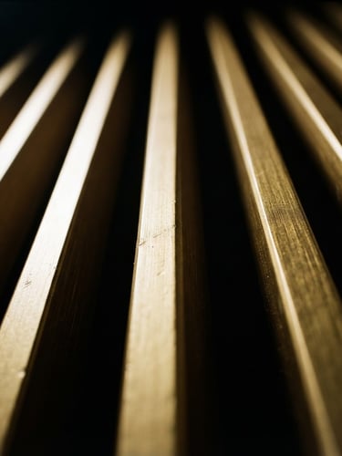 Extreme close-up of gold WPC louver ridges reflecting dramatic directional studio light, high-contrast, black and gold tones, 35mm lens.