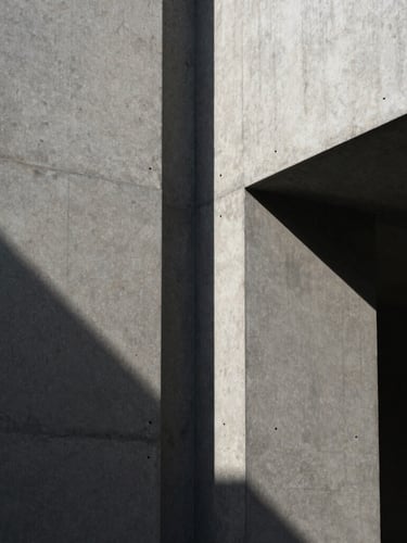 Extreme close-up of high-contrast architectural shadows on a raw concrete wall, minimalist structural lines, sober editorial photography, 35mm lens