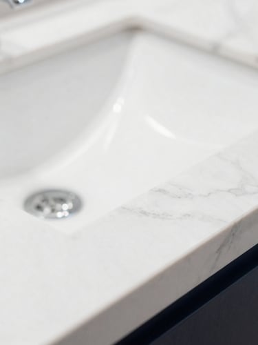 Extreme macro close-up of a flawless white marble countertop with clean light reflections, sharp focus, bright high-key daylight, zero dust particles