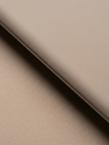 Macro photograph of a seamless matte liquid silicone edge, soft gallery lighting, warm taupe backdrop, sculptural shadow.