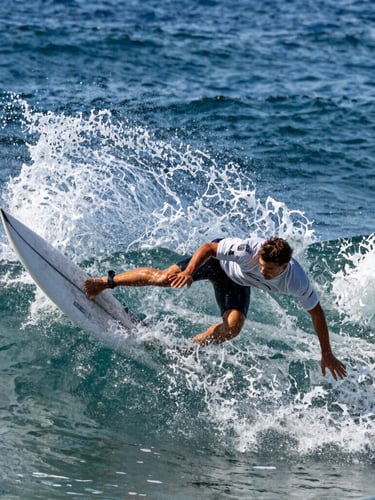 Tight, high-contrast action shot of a professional surfer executing a sharp turn, deep ocean blues, crisp morning daylight, water spray in sharp focus, 35mm