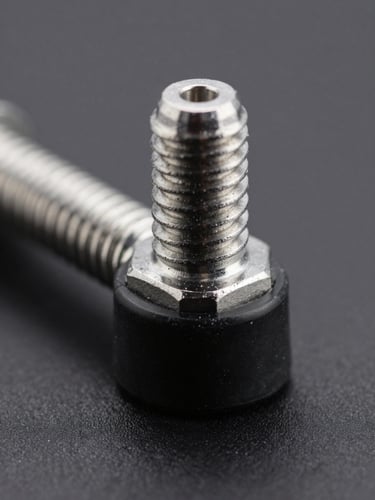 Macro close-up of a high-precision metal tie rod end with clean steel threads and black rubber boot, sharp industrial studio lighting, dark gray background, high contrast