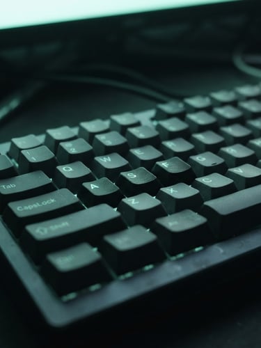 Tight macro shot of a mechanical keyboard under moody neon-mint screen glow, deep slate background, shallow depth of field