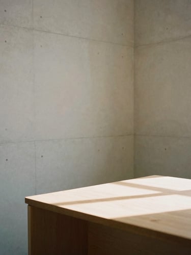 Minimalist architectural crop of a clean concrete office corner, soft indirect daylight casting geometric shadows on a warm timber desk, 35mm photography