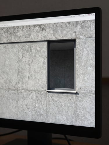 Close-up of a high-resolution architectural rendering on a studio monitor, showing precise concrete wall texture and a recessed window detail under diffuse daylight, no figures, cool neutral tones