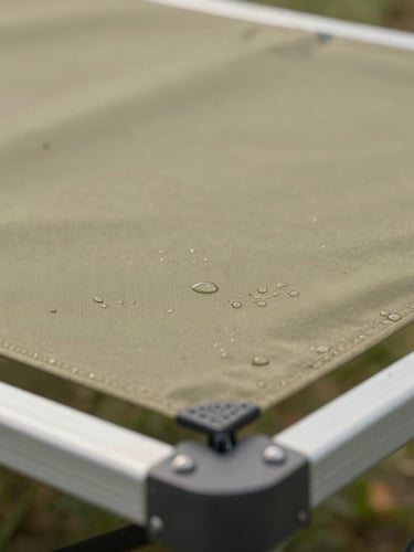 Macro detail of water-beading outdoor performance fabric over a double-powder-coated aluminum frame, natural overcast daylight, sharp focus on fabric texture, 35mm