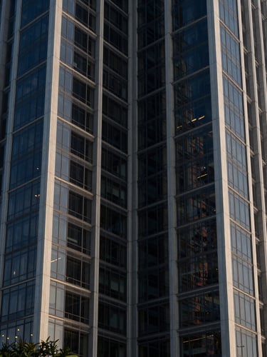 Symmetrical architectural perspective of a modern glass and steel financial tower in Panama City, cool early morning light, sharp shadows, 35mm lens