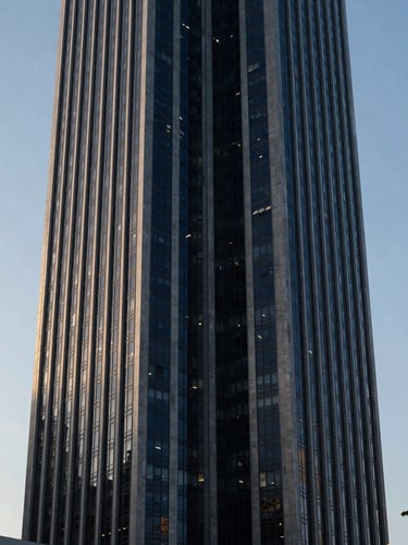 Symmetrical architectural perspective of a modern financial tower in Panama City, cool morning daylight, sharp shadows, deep navy tones, 35mm lens