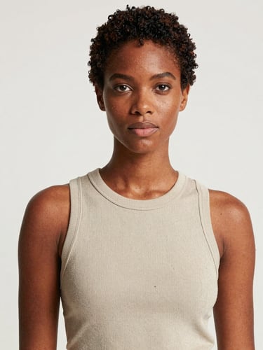 Portrait-framed commercial campaign image of Amara Osei, clean daylight studio setup, brand-neutral styling, confident direct gaze at camera, full upper-body framing, original commercial shoot lighting preserved, no added filters