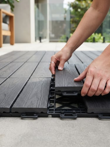 Close-up of interlocking deck tiles being snapped together by hands on a modern patio, bright architectural photography, soft natural daylight, clean neutral tones, high-end interior design, sharp focus, 35mm