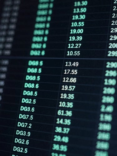 Extreme close-up of a dark digital interface showing live real estate inventory grids with neon-mint active indicators, cool screen glow, high contrast.
