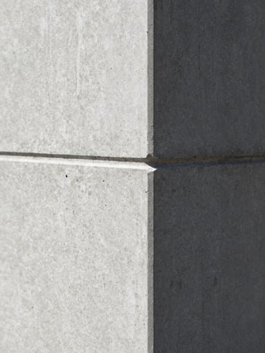 Macro close-up of a structured architectural concrete corner, sharp directional shadows, minimalist and precise, high-contrast.