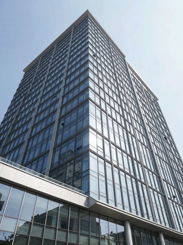Wide-angle crisp architectural photograph of a modern commercial office building exterior, bright natural daylight, clean glass reflections, sharp focus