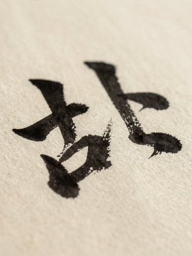 Portrait orientation shot of calligraphic ink texture on coarse handmade paper, showing the raised edge of the wet black stroke, macro photography, soft natural side-light, warm ivory background