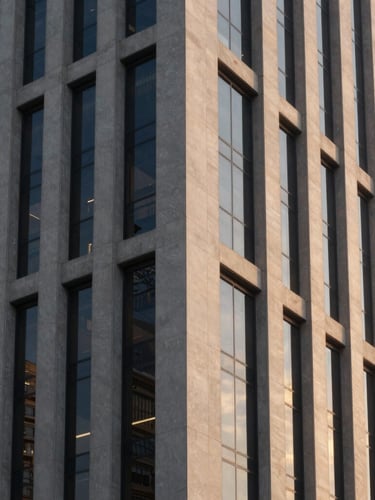 Architectural detail of a modern corporate building facade in São Paulo, glass and concrete reflecting soft sunset light, premium corporate photography, 35mm