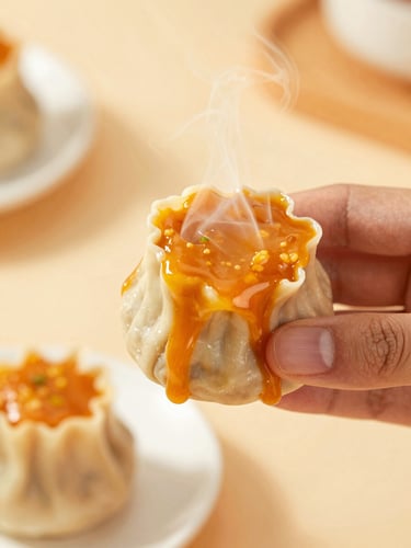 Macro kitchen shot of a hand lifting a single dimsum piece covered in thick, melting orange mentai sauce, steam rising, warm kitchen background