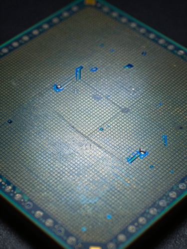 Wide panoramic macro shot of a silicon wafer surface filling the frame edge to edge, regular grid of processor dies visible under cool overhead studio strobe light, electric-blue interference patterns in the silicon oxide layer, no hands, no text, no people