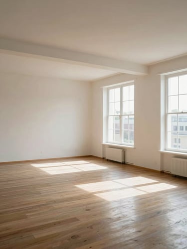 A wide-angle landscape view of a fully restored, immaculately clean apartment interior, light-filled with polished floors and natural daylight streaming through large windows.