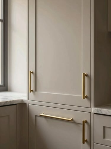 Straight-on architectural detail of custom kitchen cabinetry, brushed brass hardware, and clean marble veining, warm natural light, 35mm