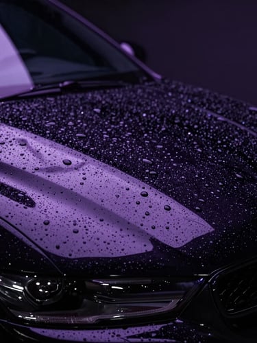 Sleek automotive detailing photography, extreme close-up of water beading on a freshly coated deep black ceramic hood, dramatic low-key studio lighting with vibrant lavender LED reflections, ultra-sharp detail, 85mm lens