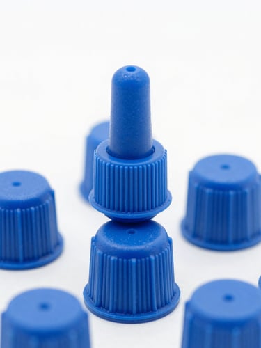 Macro photo of sterile blue plastic dropper caps on a high-key clean white background, sharp industrial focus, studio lighting