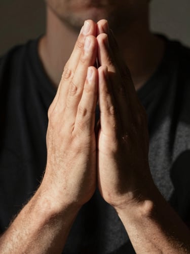 Dramatic documentary close-up of two hands clasped together in prayer, high-contrast natural light, deep shadows, warm amber tones, raw emotional atmosphere.