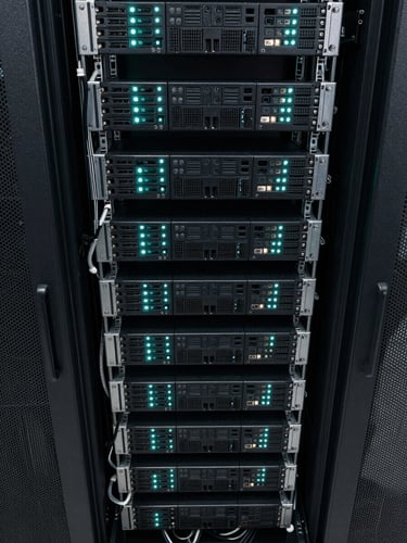 Close overhead view of dense server rack cabling in a colocation facility, cyan-tinted indicator lights punctuating rows of black hardware, sharp technical detail, no people