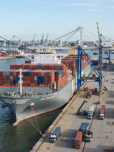 Wide-angle sharp corporate photography of a modern deep-water container ship at port, crisp neutral white daylight, slate and white tones, sharp focus, 35mm