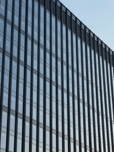 Vertical shot of modern corporate headquarters facade, clean architectural lines of glass and dark steel, sharp contrast against clear sky