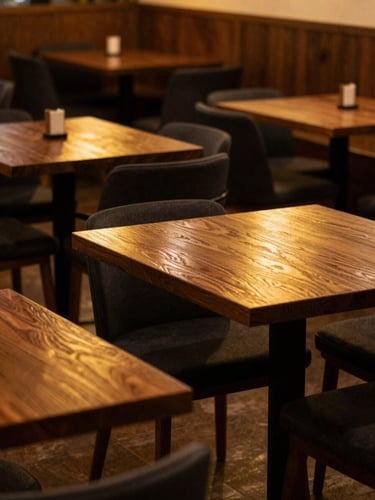 Atmospheric wide shot of the Shahre Naw dining room, soft golden light reflecting off deep walnut wood tables, matte black accents