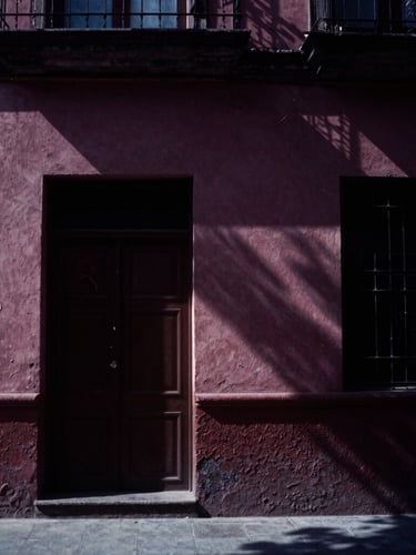 Moody film photography of a high-contrast CDMX film set, soft natural light, deep plum shadows, cinematic 35mm