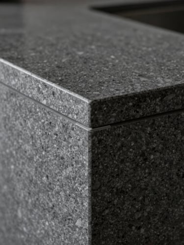 Extreme close-up of a flawless 45-degree miter joint on a dark grey quartz sinter countertop, dramatic side-lighting revealing the perfect seamless edge, sharp focus