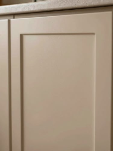 Macro straight-on architectural shot of a flawless, factory-finished kitchen cabinet door, soft natural side-light reflecting off a smooth matte ochre-tinted surface, zero dust, crisp clean edges.