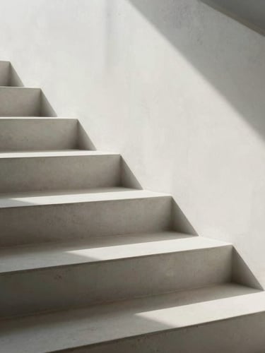 Abstract architectural detail of clean white concrete stairs casting soft, geometric shadows under bright, diffused daylight.