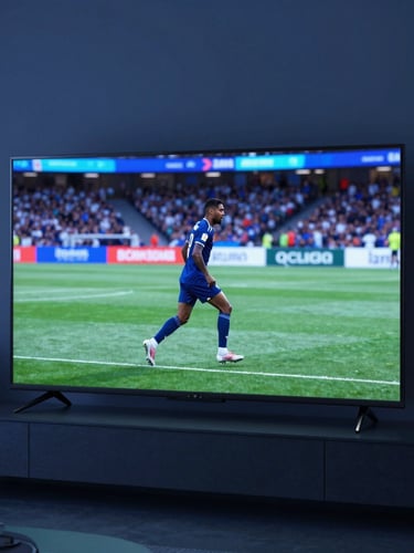 Sleek modern television screen displaying vibrant live sports in a cool-toned contemporary living room, subtle blue ambient light, shallow depth of field