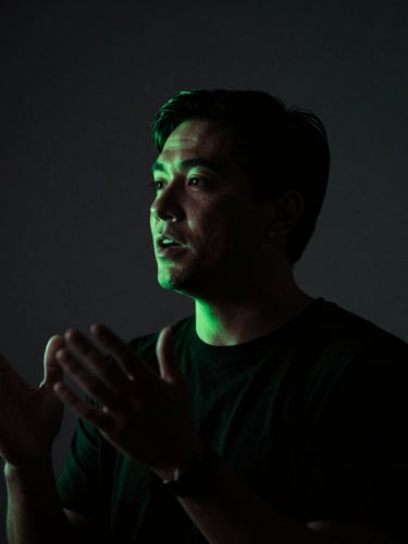 Expressive portrait of a speaker in mid-speech, dramatic low-key studio lighting, dark charcoal background, sharp neon green accent light on the silhouette, shallow depth of field, 35mm
