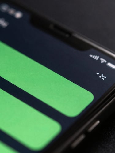 Extreme close-up macro shot of a physical Android device screen displaying a fluid, high-fidelity UI transition with bright green accents, dark slate background, moody rim lighting