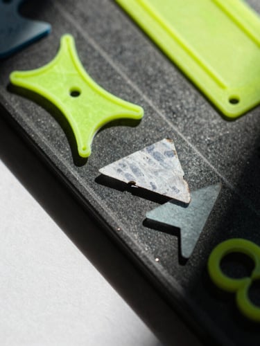 Extreme macro shot of resin-embedded neon plastic scraps and handwritten paper fragments, harsh direct sunlight, sharp dark shadows, high-contrast saturated tones, 35mm film texture