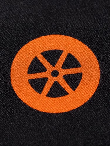 Extreme close-up of raised safety orange print texture on heavy-weight black cotton fabric, direct high-contrast sunlight emphasizing the weave.