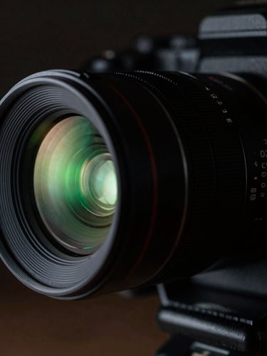 Close-up macro shot of a fully rigged anamorphic lens, camera tally light glowing neon green, low-key dramatic lighting, high contrast dark tones.