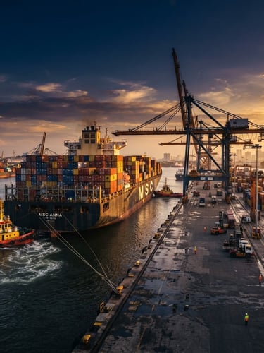 Wide-angle dramatic shot of a massive container ship docking at Tanjung Priok port during golden hour, cinematic industrial photography, deep navy and steel tones