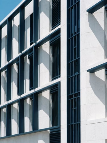 Architectural detail of a high-end Sarasota office building, clean geometric shadows on white limestone, bright natural Florida daylight, desaturated navy and warm gold tones, 35mm lens.