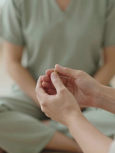 Close-up of hands during a Reiki session, soft focus, warm editorial photography, natural daylight, muted sage and stone tones, 35mm