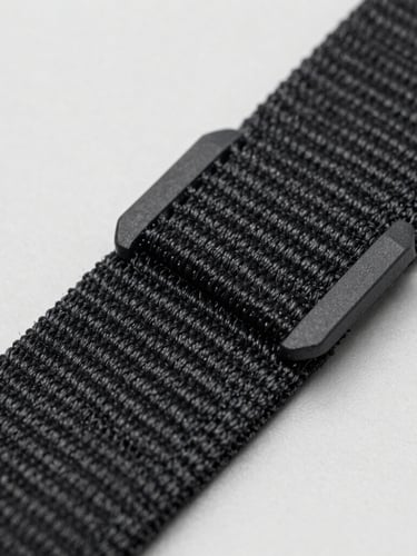 Macro detail shot of heavy-duty nylon stitching on a tactical strap, high-contrast studio lighting, revealing fabric texture and fiber strength