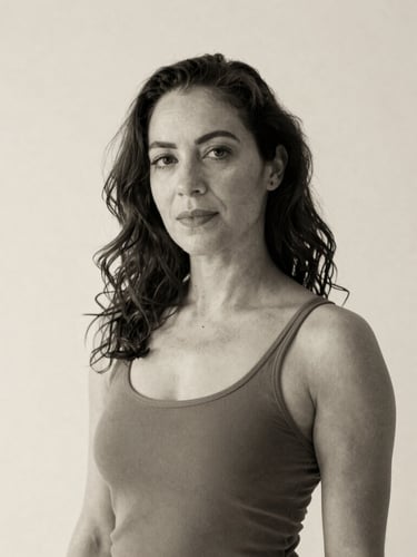 Elegant black and white portrait of dance educator Gwynenn Taylor Jones, soft natural lighting, neutral cream background, warm tones.