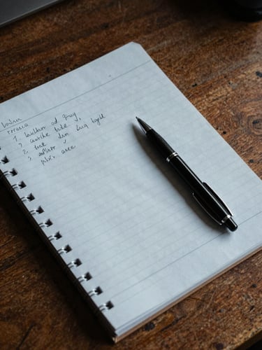 Overhead close study of an open manila case file on a worn wooden desk — handwritten notes in the margins, a ruled notebook alongside, a black ballpoint pen resting on the page, cool tungsten archive lighting raking across the paper surface, no faces or legible names visible